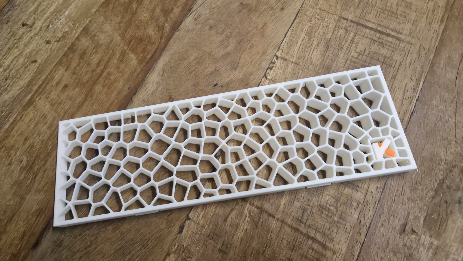 Rejilla impresa en blanco con patrón Voronoi y el símbolo de KDS en naranja